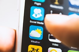 Thumb about to press on a mobile phone with a weather application